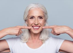 年长的白人妇女微笑展示完美的牙齿