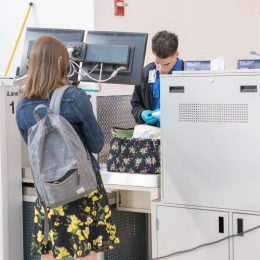 乘客通过TSA安全在纽约皇后区的拉瓜迪亚机场。TSA代理检查液体在一个女人的包。用佳能5 d Mark lV。